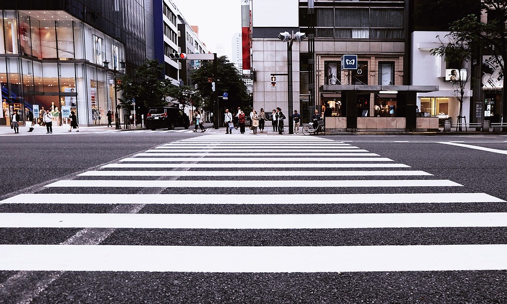 A close-up of a crosswalk painted on a downtown road.