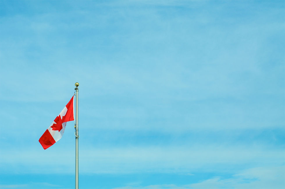 A blue sky as a background to the Canadian flag waving in the wind.