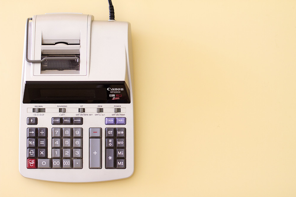 An adding machine atop a yellow background